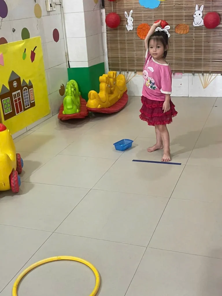 Bé chuẩn bị ném bóng trúng đích trong giờ vận động tại Hoa Nắng